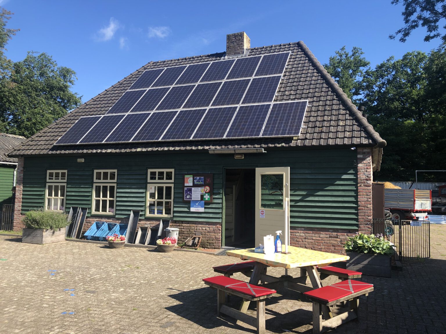 terras kinderboerderij met tafels en bankjes